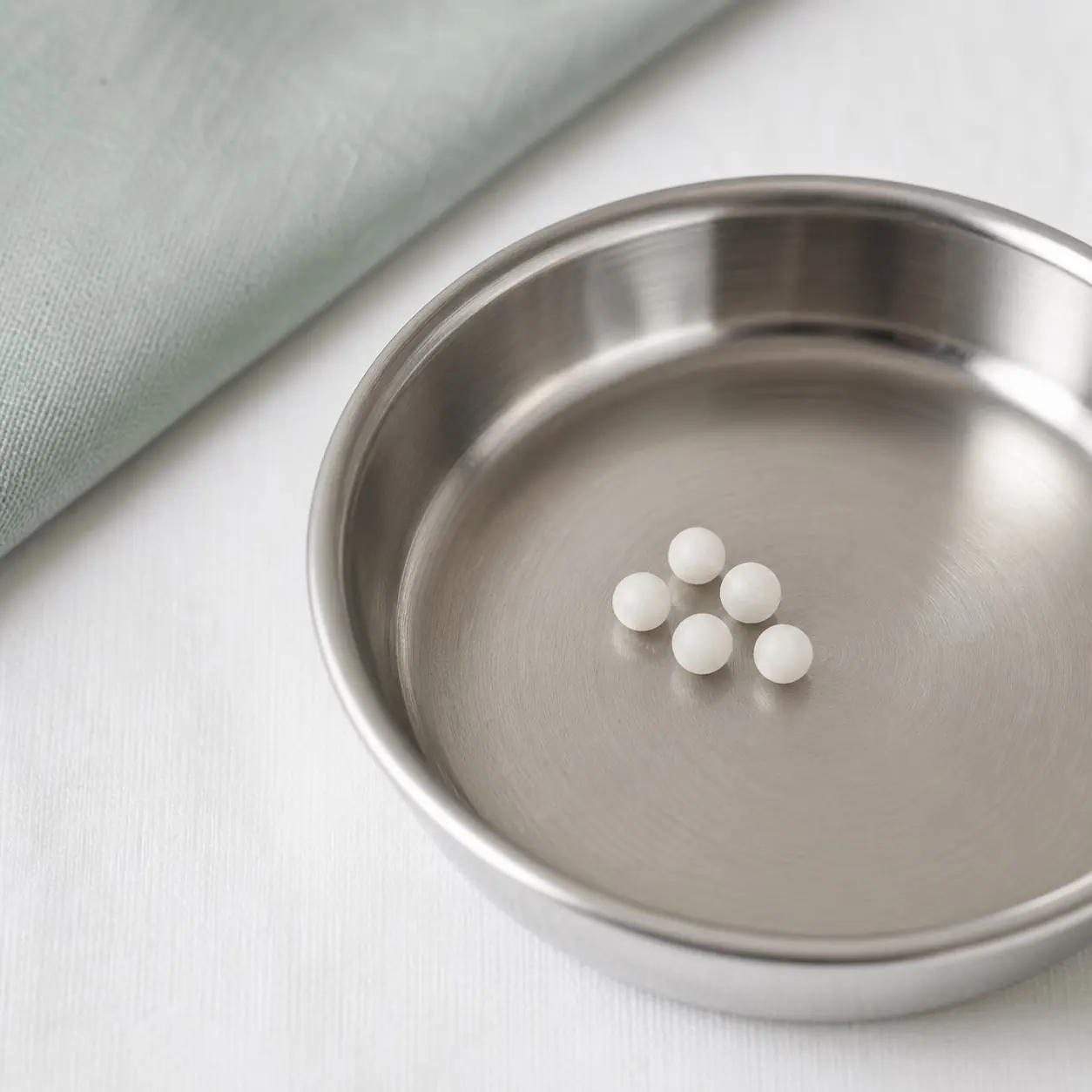 A few tiny hormone pellets in a small stainless dish