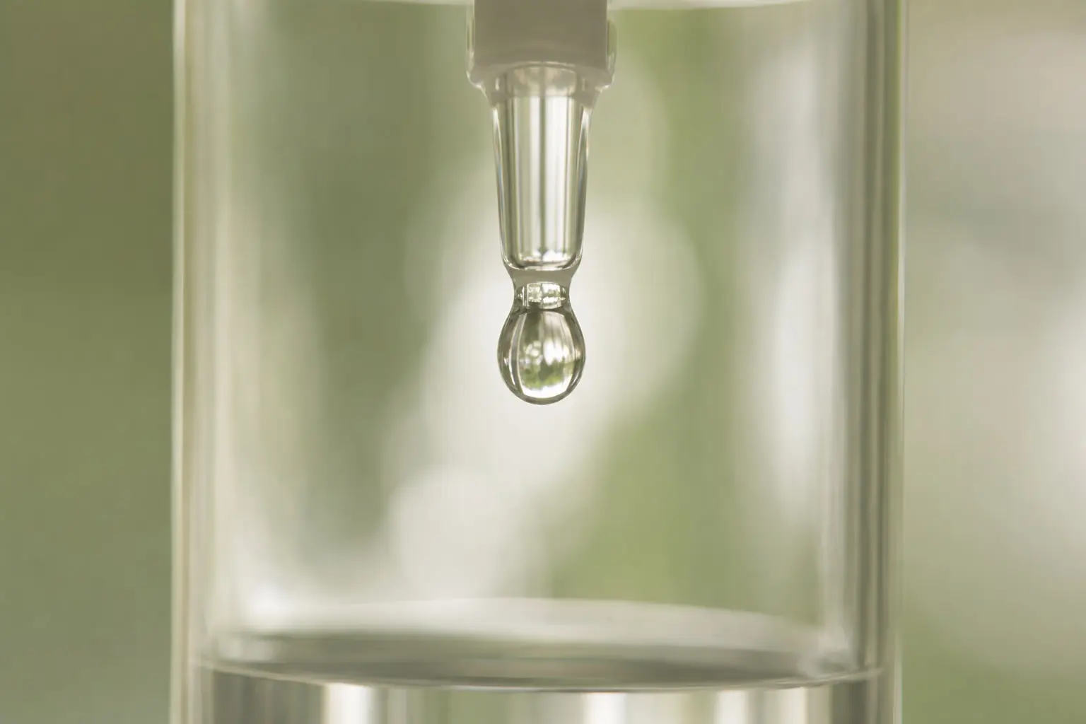 A single drop forming inside a clear IV drip chamber