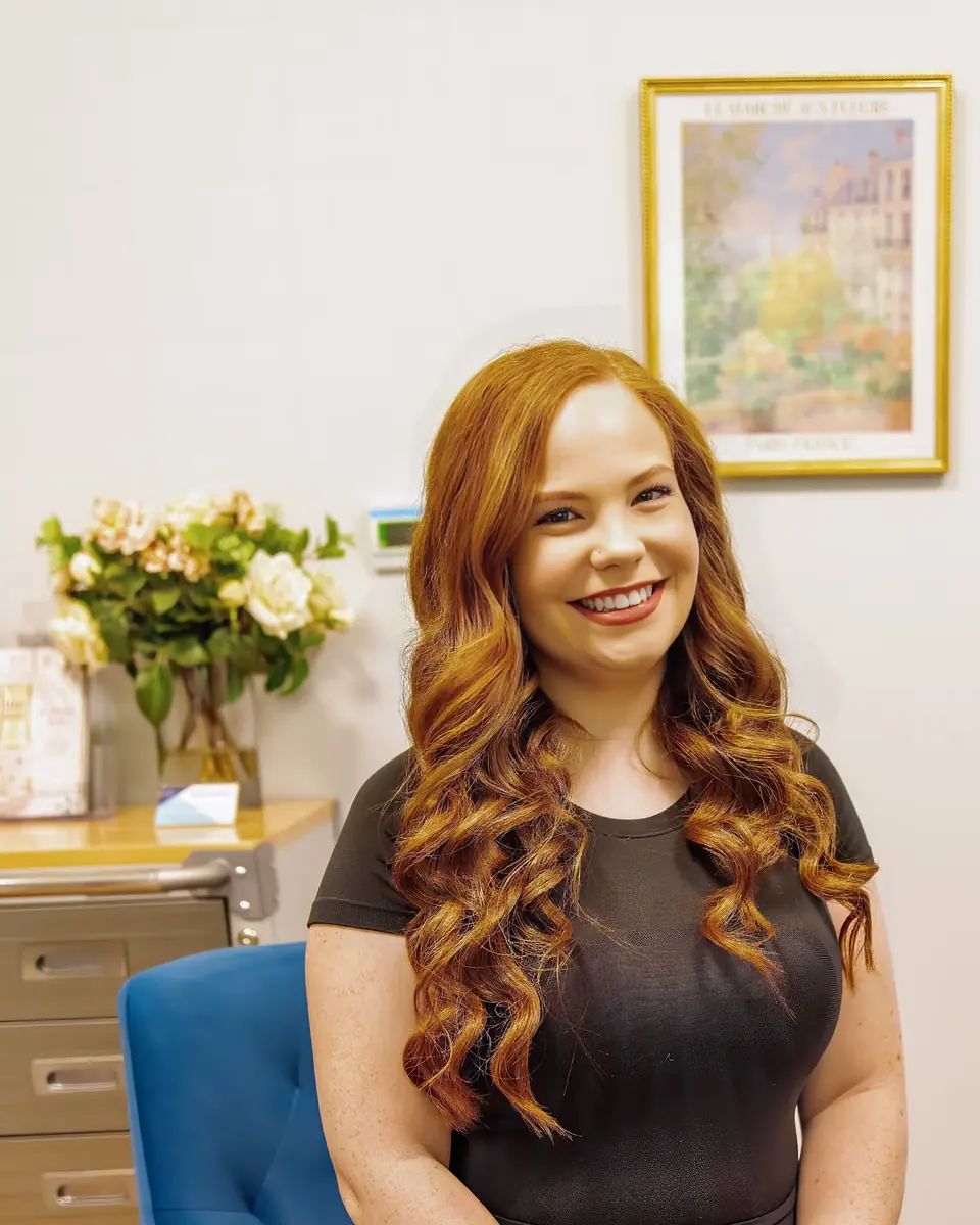A smiling patient seated in a consult room at Healing Advanced Solutions