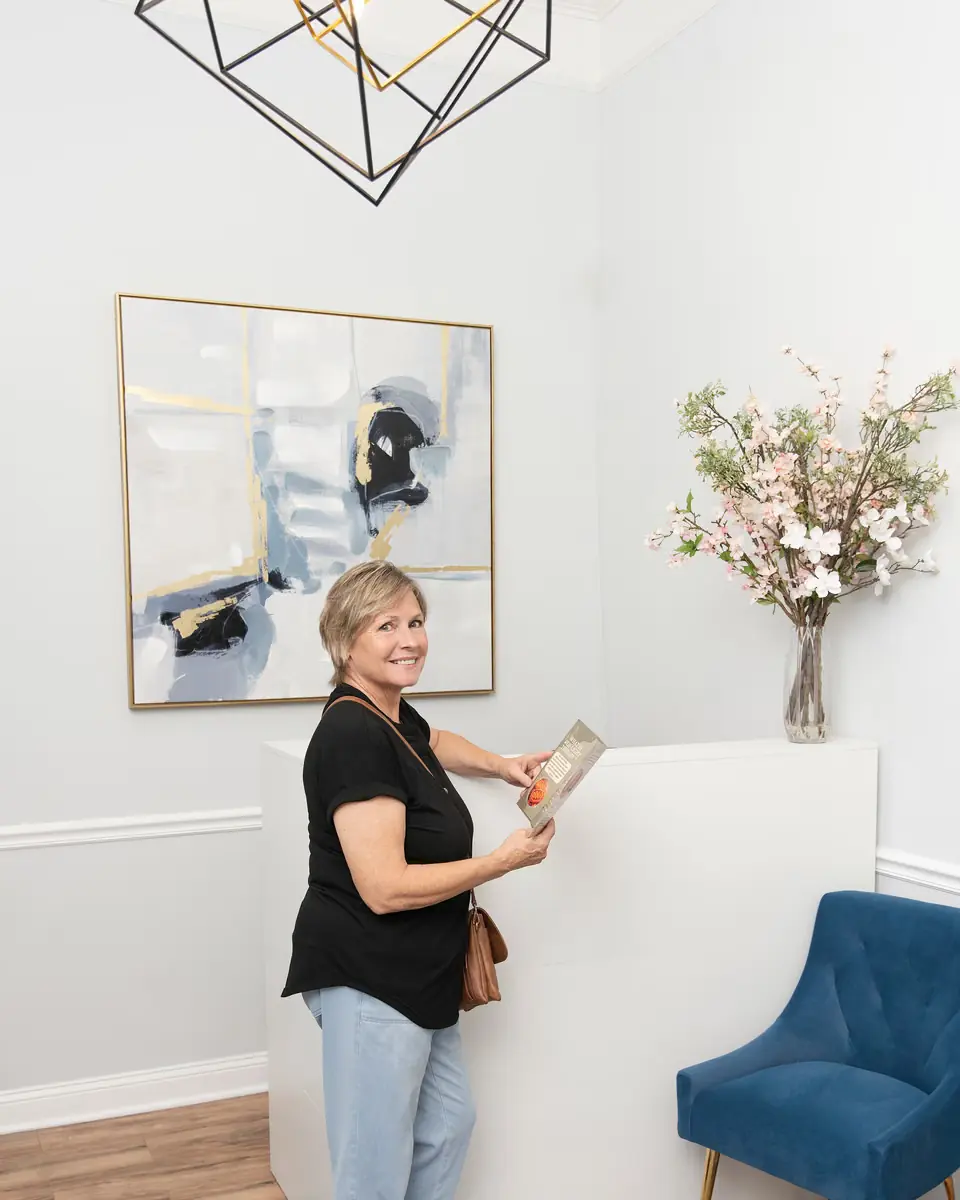 A patient at the front desk with the clinic's program guide at Healing Advanced Solutions