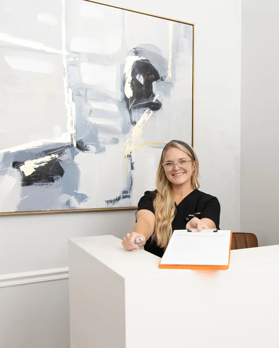 A medical assistant prepares intake paperwork at Healing Advanced Solutions