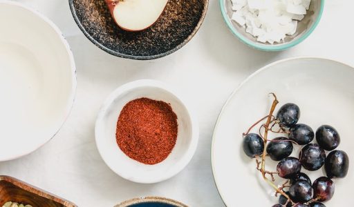 An overhead shot of fruits, seeds and spices in bowls