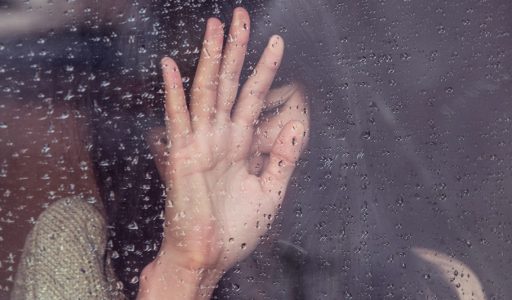 woman touch rainy glass